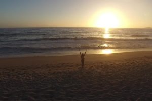 夕阳海边的女孩迎风挥手